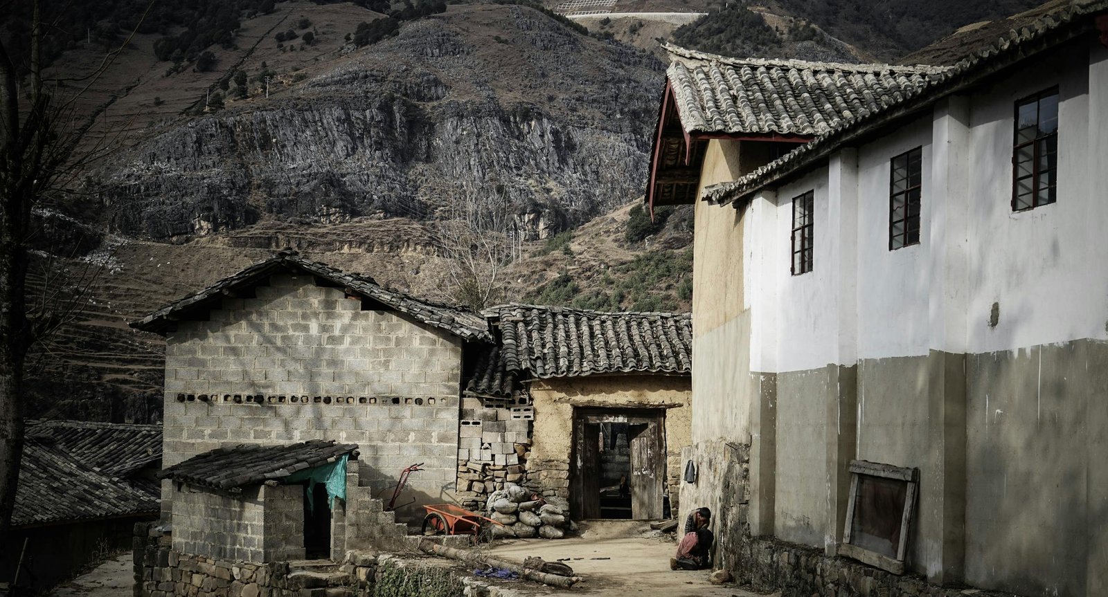 An old rustic house located in a rural village with mountainous backdrop, exemplifying traditional architecture.