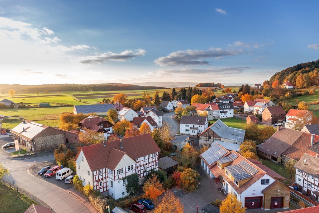 Charming aerial view of a rural village in autumn with vivid colors and clear skies.