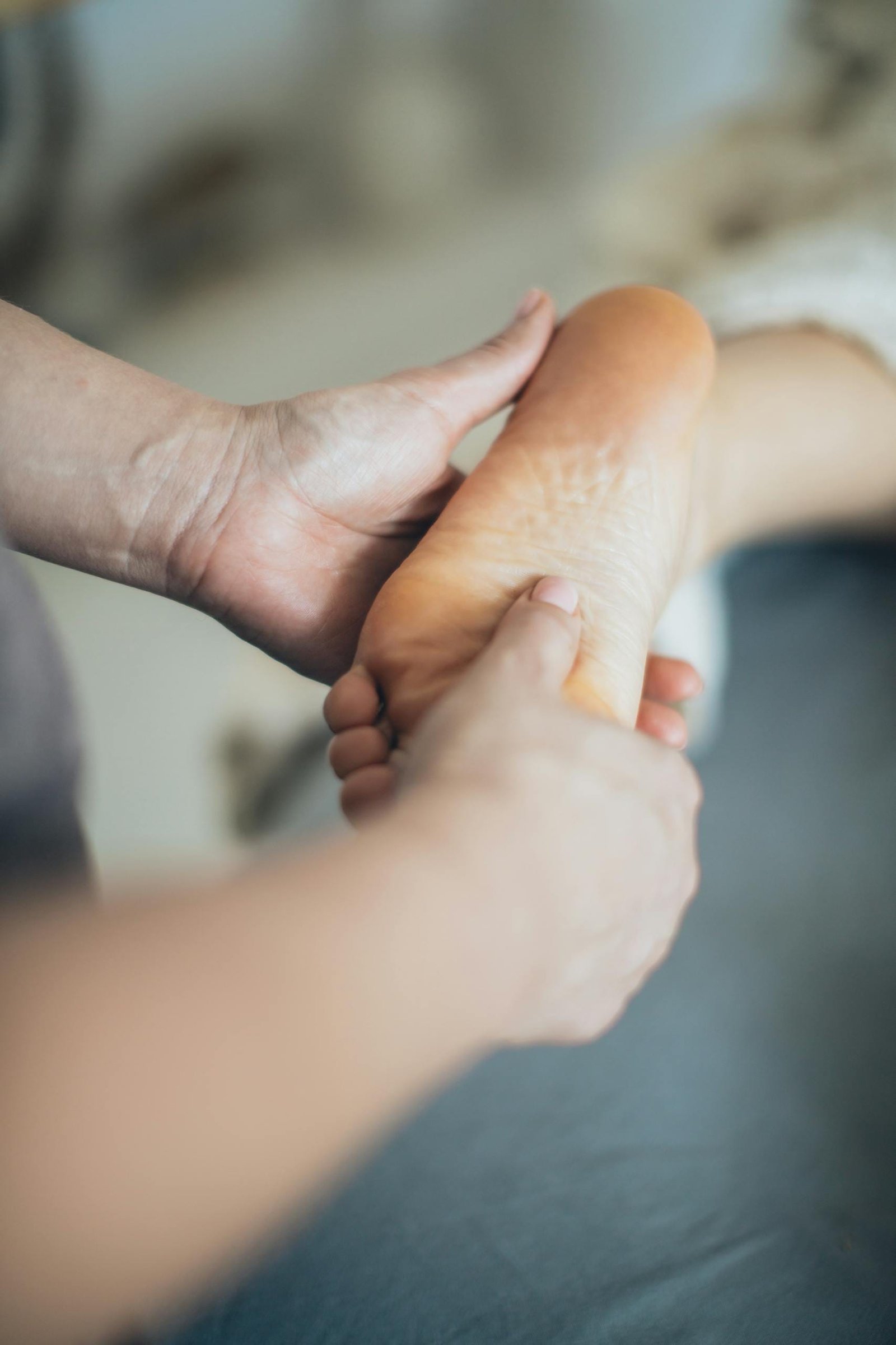 Close-up of hands giving a relaxing foot massage in a spa setting, promoting wellness.