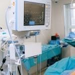 Close-up of vital signs monitor in a modern operating room setup.