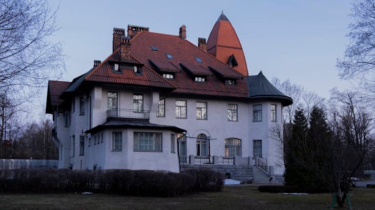 Elegant mansion with distinct red roof in St. Petersburg, Russia.