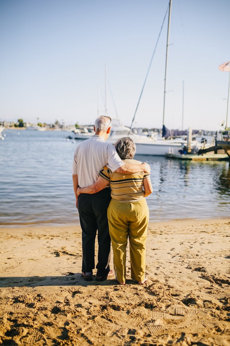 Senior couple embracing on a sunny beach. Perfect for travel and lifestyle themes.