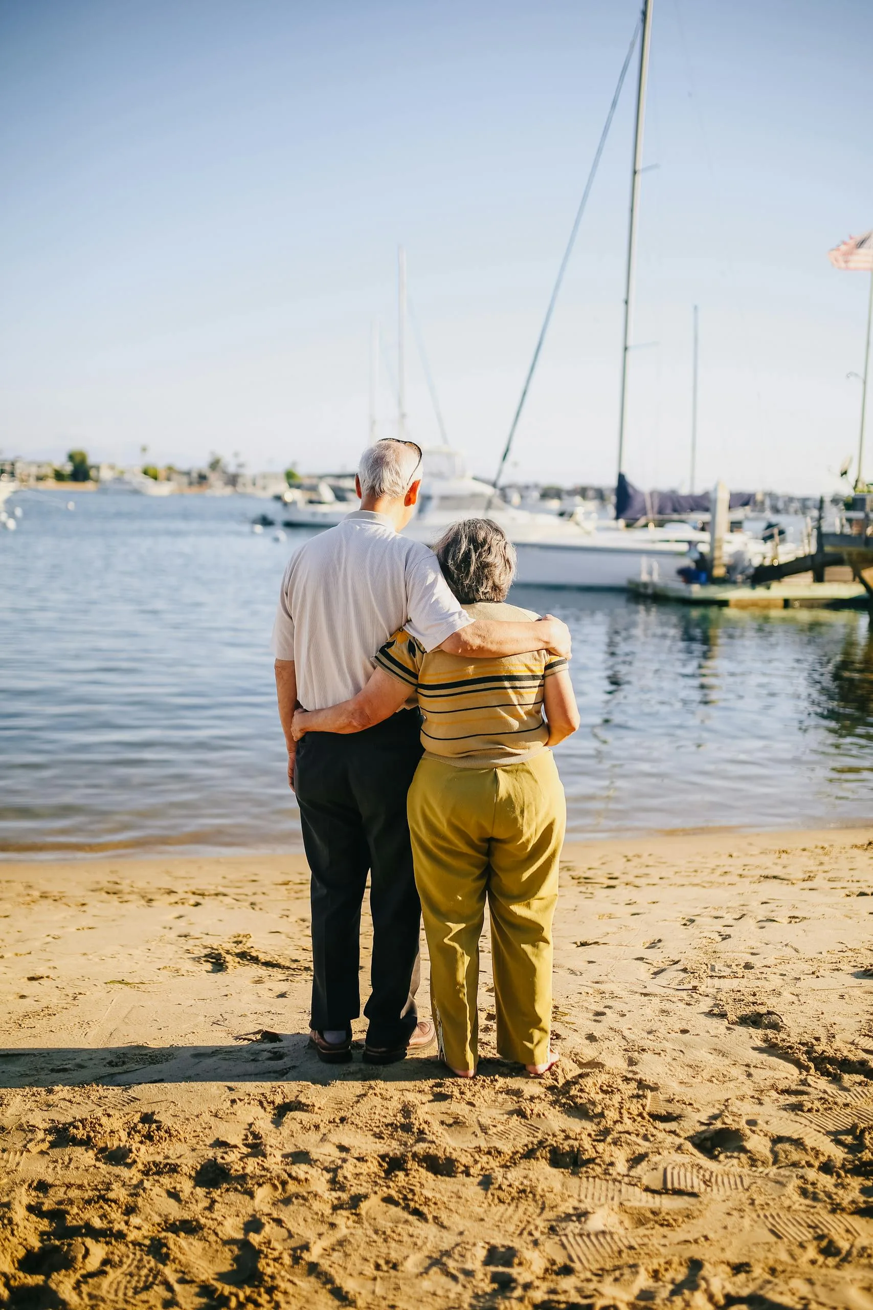 Senior couple embracing on a sunny beach. Perfect for travel and lifestyle themes.