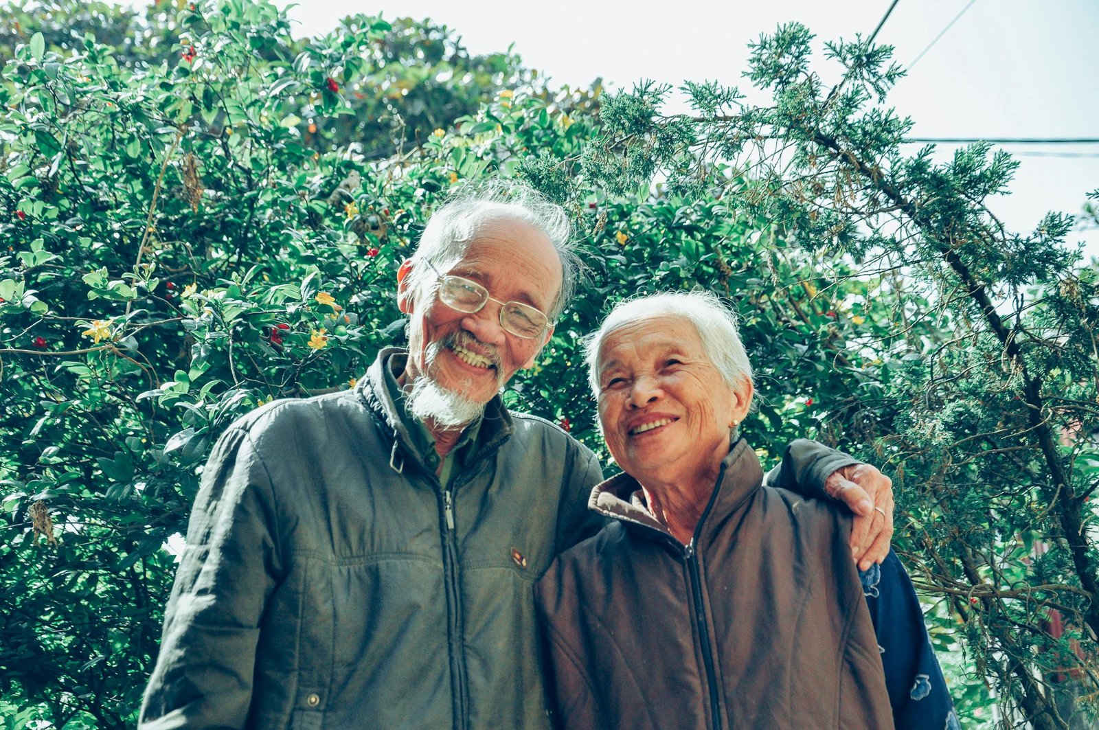 Senior couple enjoying a joyful moment together in a lush garden setting, exuding love and happiness.