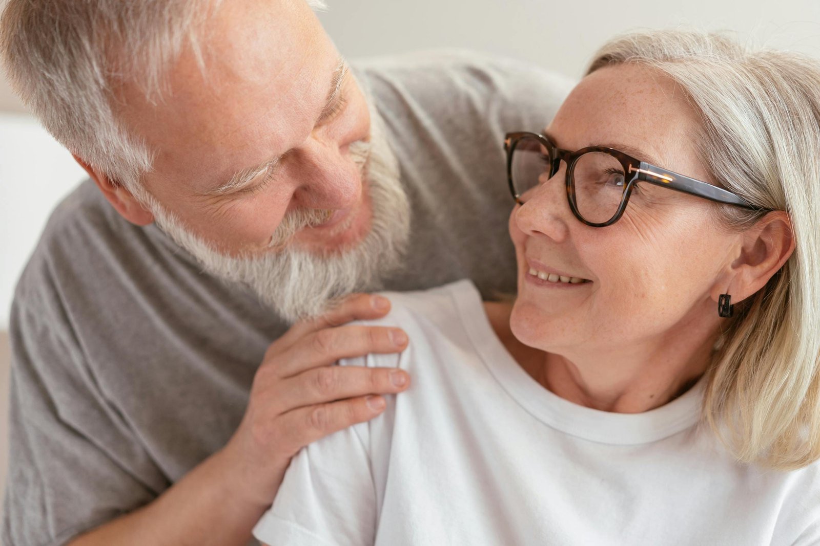 Senior couple smiling and enjoying each other's company indoors.